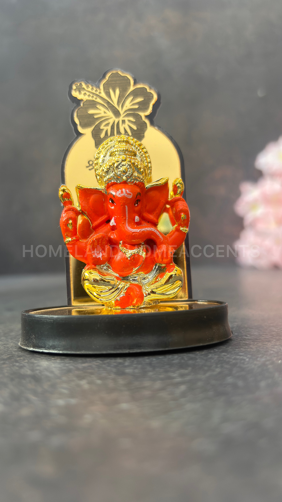 Vibrant Orange Ganesh Idol with Hibiscus Backdrop
